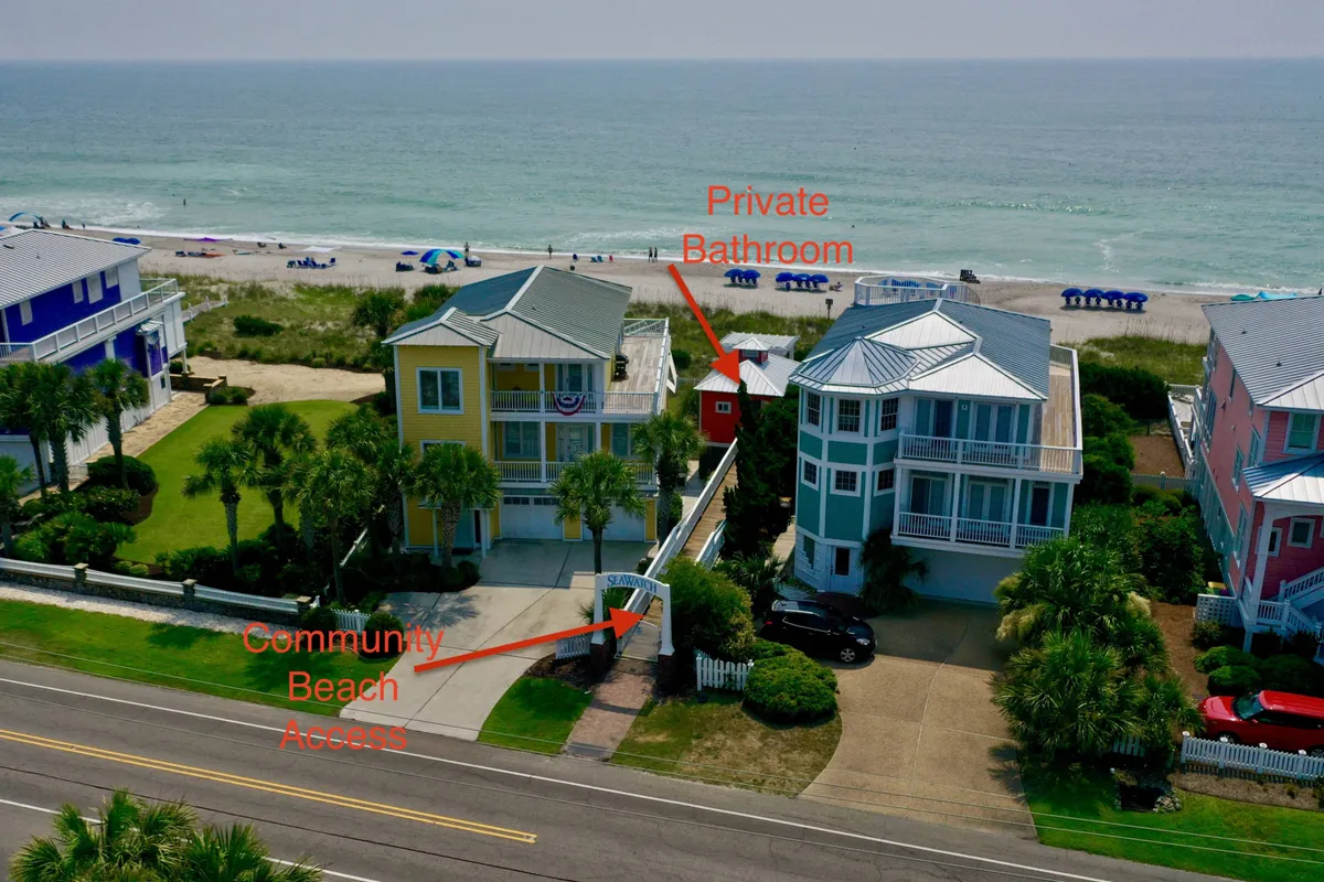 A welcoming exterior shot featuring the community’s beach access point lined with colorful houses and lush palm trees, creating a relaxed, vacation-like atmosphere that leads families directly to the sand and surf.