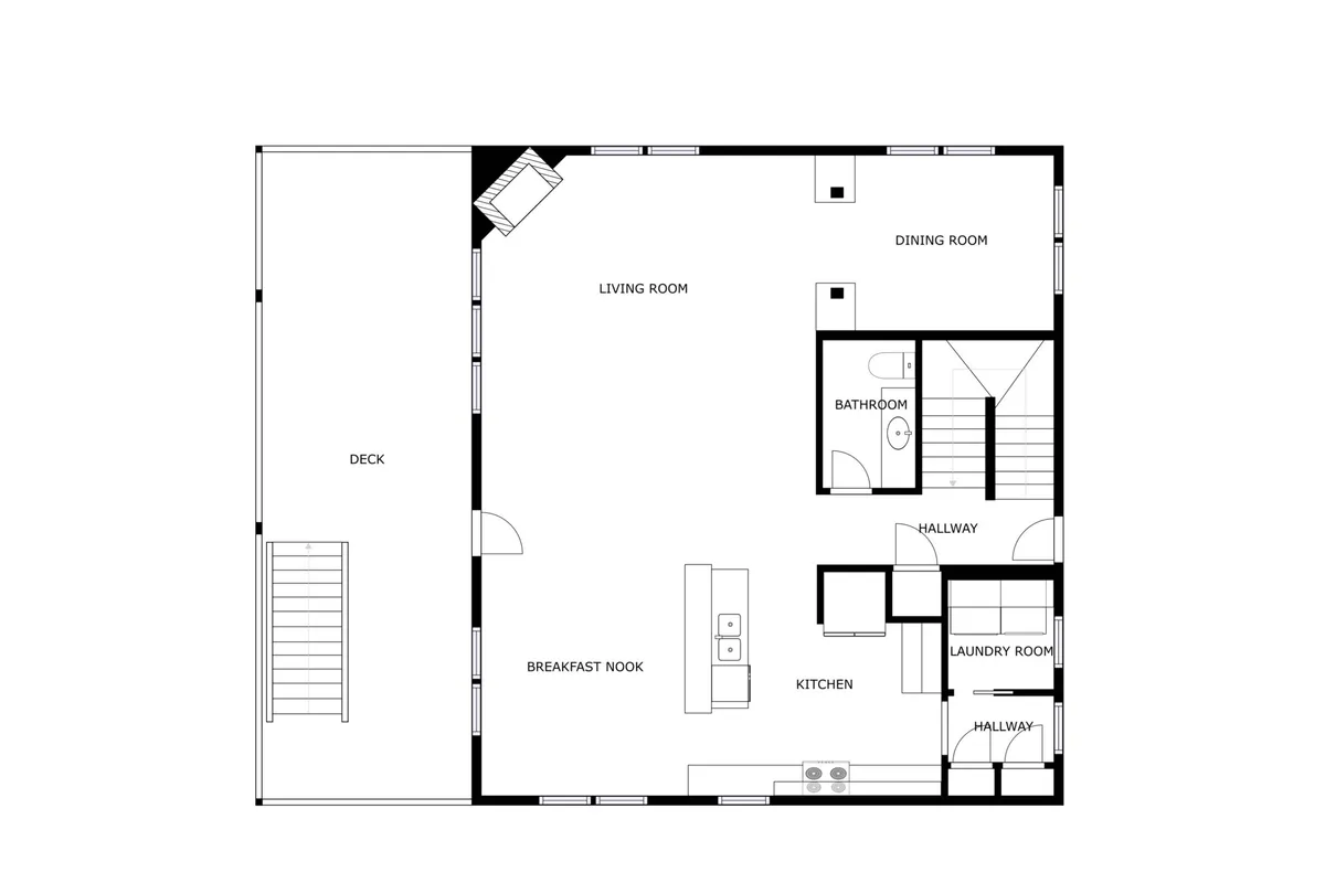 An open-plan living, dining, and kitchen area with seamless transitions to a deck. The space is functional yet cozy, with defined areas for family meals, gatherings, and daily routines including laundry.