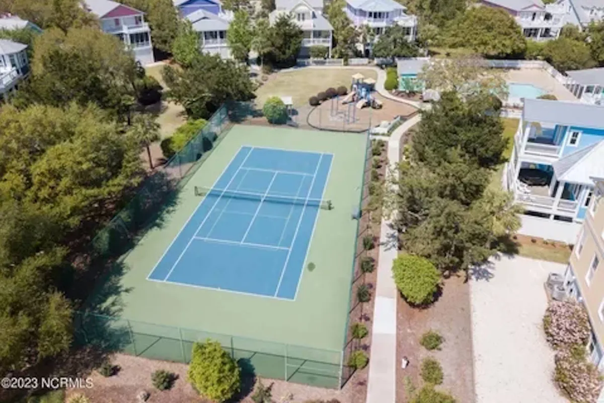 A vibrant exterior scene showcasing a tennis court, surrounding greenery, a playground area, and a swimming pool, all in one frame. The mood is energetic and playful, with visible spaces for tennis matches, family gatherings, and children's adventures.
